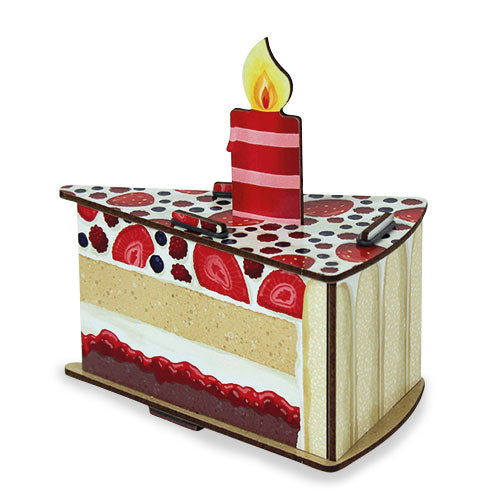 A gift box designed to look like a slice of birthday cake with layers and a candle on top.