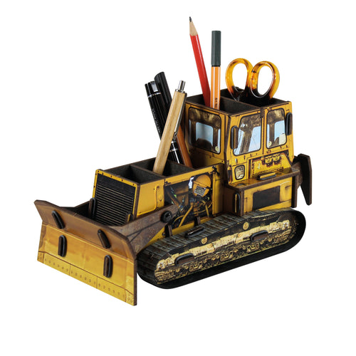 A model of a yellow bulldozer made of wood, designed as a pen pot with compartments for storing writing instruments and a shield that acts as a phone holder.