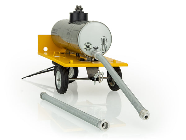 A kovap toy cistern trailer made of metal with a yellow base and gray tank, displayed with its pipe connectors