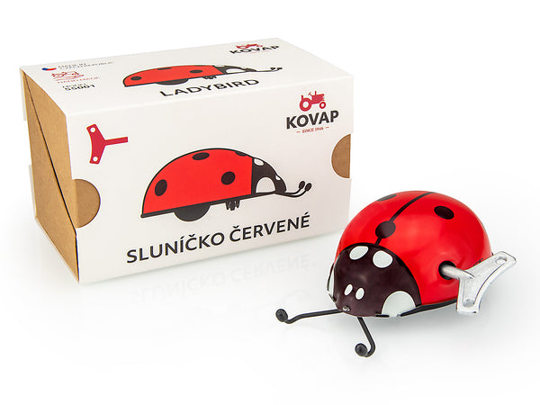 Red kovap ladybug toy with packaging on a white background