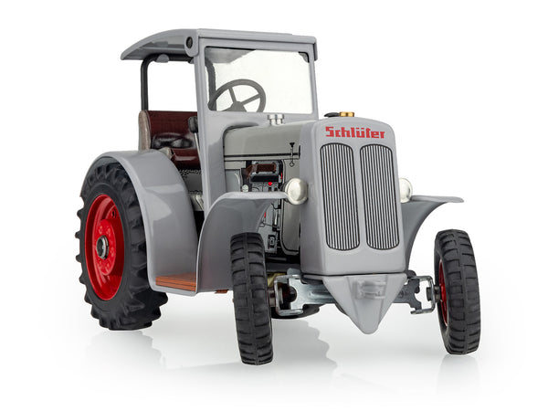 A grey SCHLÜTER DS 25 toy tractor with a roof, featuring a steering wheel, wheels, and a key drive mechanism.