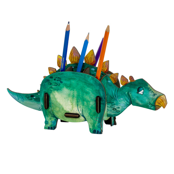 A Stegosaurus-shaped pen pot with multiple compartments, filled with colored pencils. The pen pot is painted in various shades of green with orange spikes on its back.