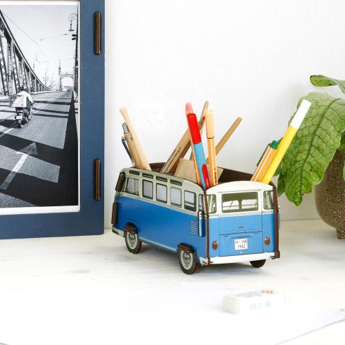 Blue and white van-shaped pencil holder with stationery items on a white surface.