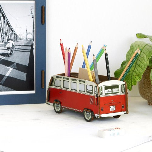 Red and white van-shaped pencil holder with colorful pencils on a white surface.