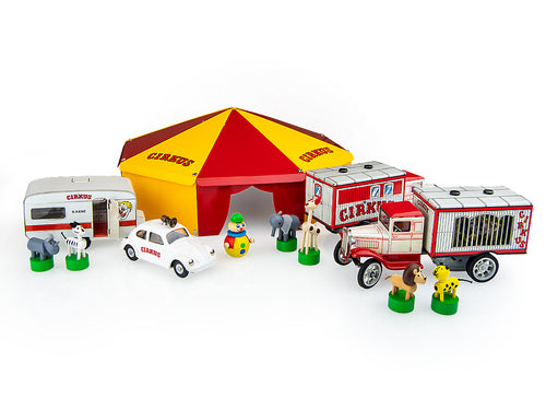 A collection Kovap of circus-themed toy models including a red and yellow striped tent, a white VW Beetle with a loudspeaker, a menagerie wagon, a metal tent, six wooden animals on magnetic bases, and a wooden clown figure.