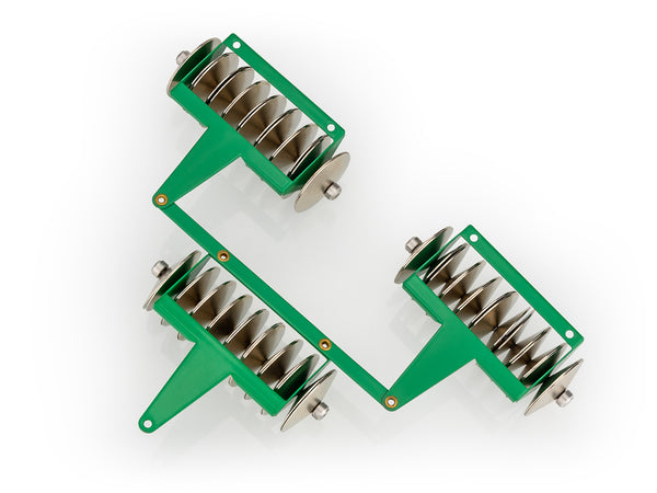 A set of toy rotavators with green handles and silver-coloured rollers, set against a white background.